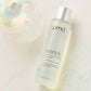 Enrich Softening Antioxidant Essence laying down next to clear globe