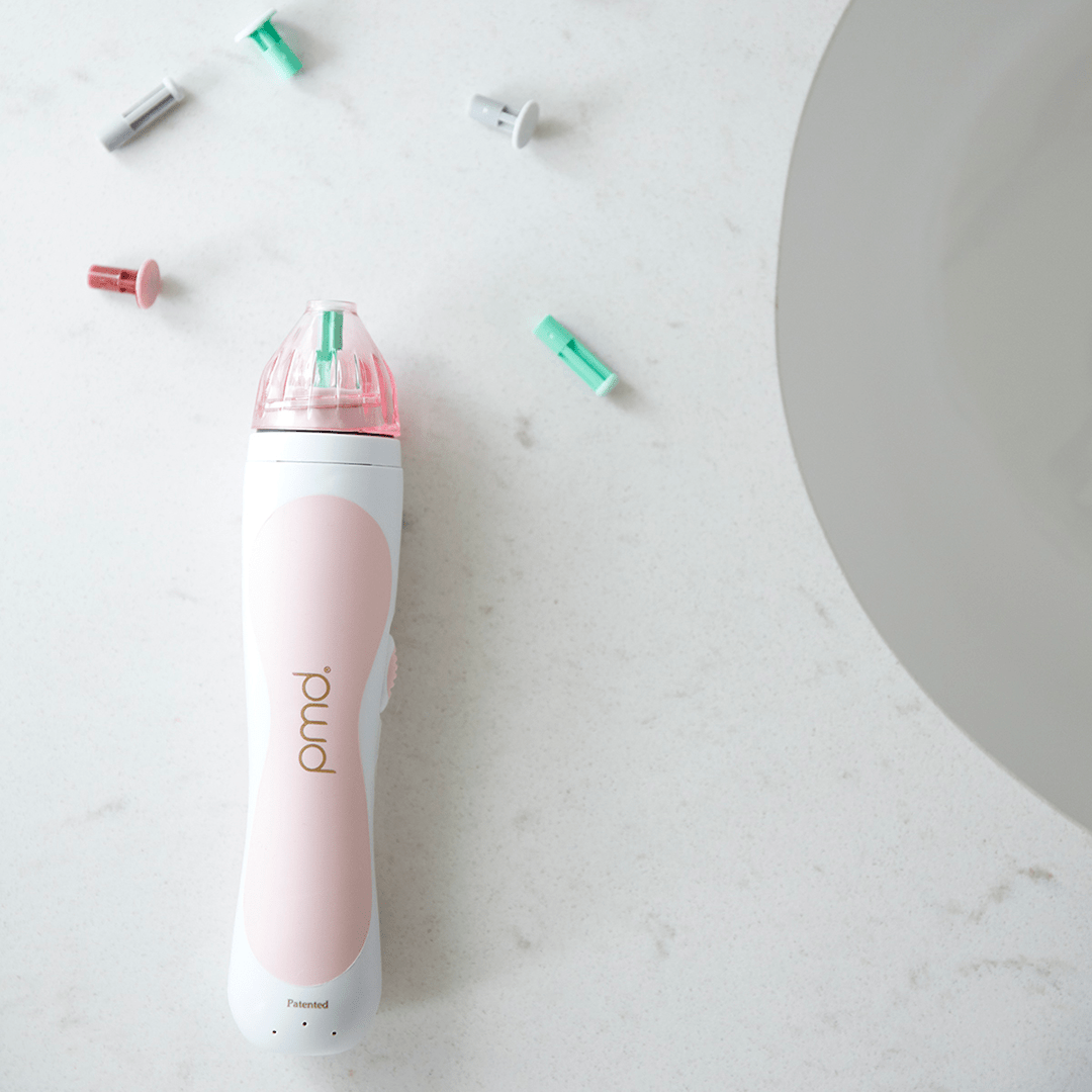 1203?Personal Microderm Classic in Blush on countertop surrounded by discs